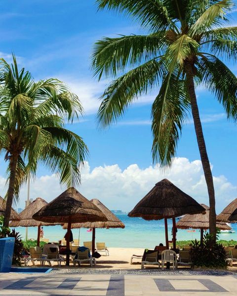 Beach umbrellas and chairs at a resort on the Caribbean coast of Cancún, Mexico