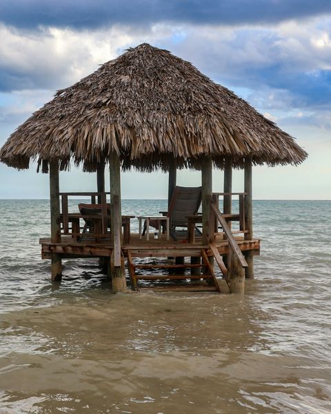 Thatched-roof beach hut on the shoreline in Westmoreland, Jamaica