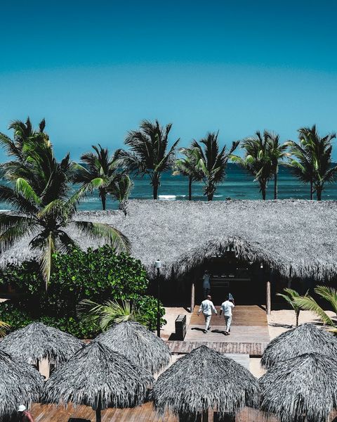 Tropical beach resort with thatched roofs and turquoise water in Punta Cana, Dominican Republic